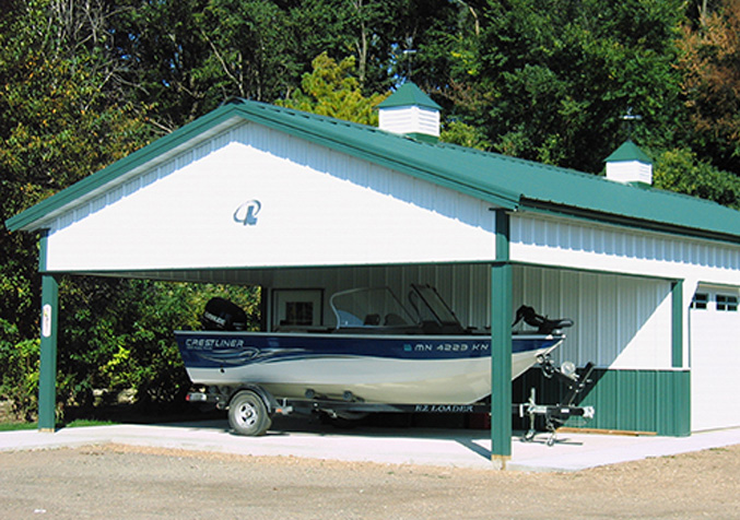 white barn, blue roof with overhead protecting a speedboat under it
